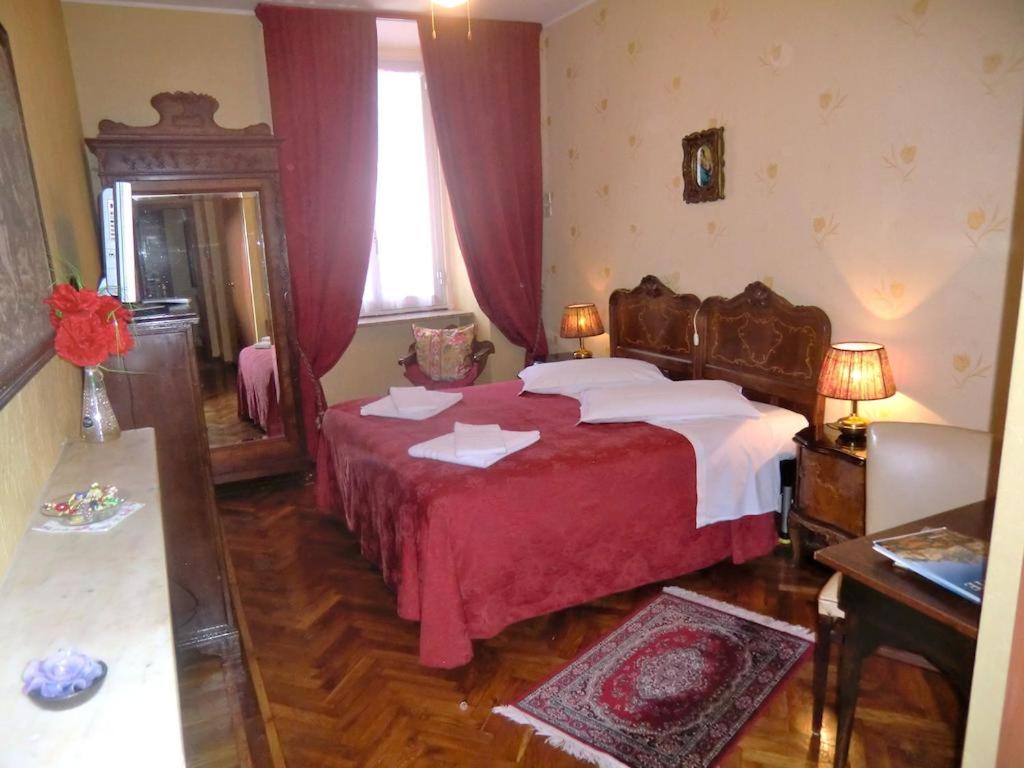 a bedroom with a large bed with a red blanket at HOTEL SARA in Turin