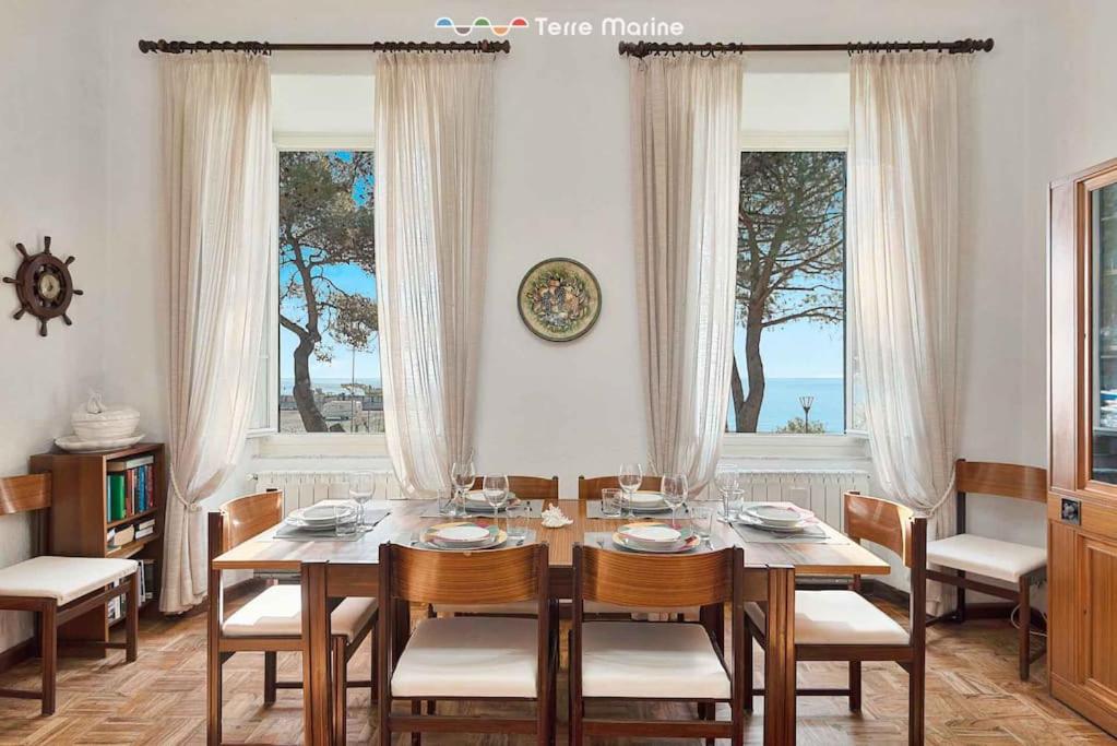 a dining room with a table and chairs and windows at Musica del Mare in Monterosso al Mare