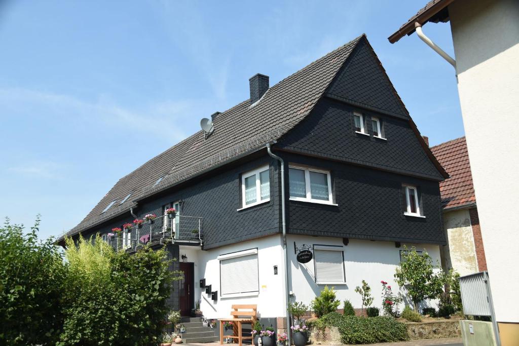 a black and white house with a black roof at Ferienwohnung "Im alten Pfarrhaus" in Bad Zwesten