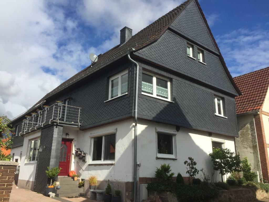 uma grande casa branca com um telhado preto em Appartement Im alten Pfarrhaus em Bad Zwesten