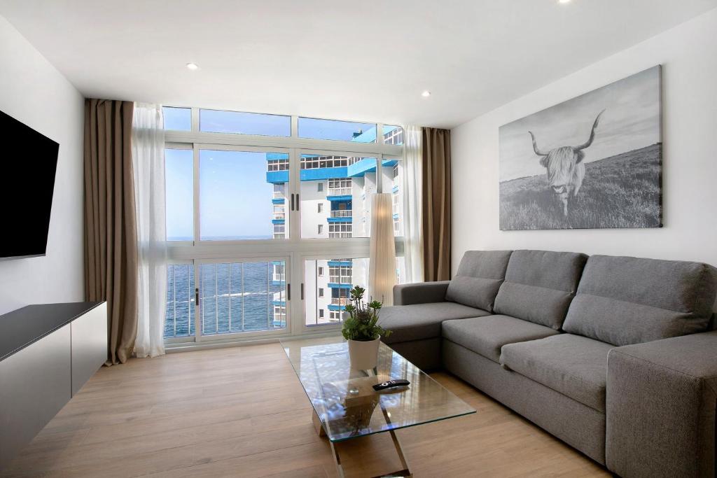 un soggiorno con un divano e una grande finestra di Luxury Loft Mar y Sol 1 a Tacoronte