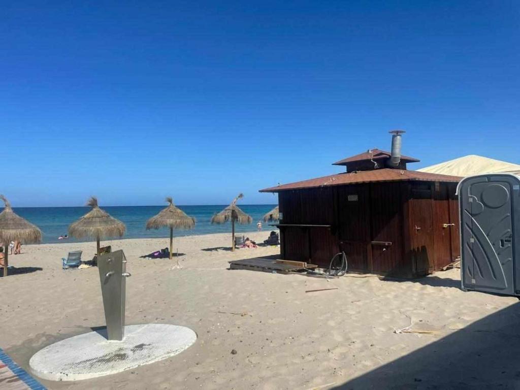 eine Holzhütte am Strand mit dem Meer in der Unterkunft Monacodeluxe 1ºlinea Mediterráneo super equipado in La Manga del Mar Menor