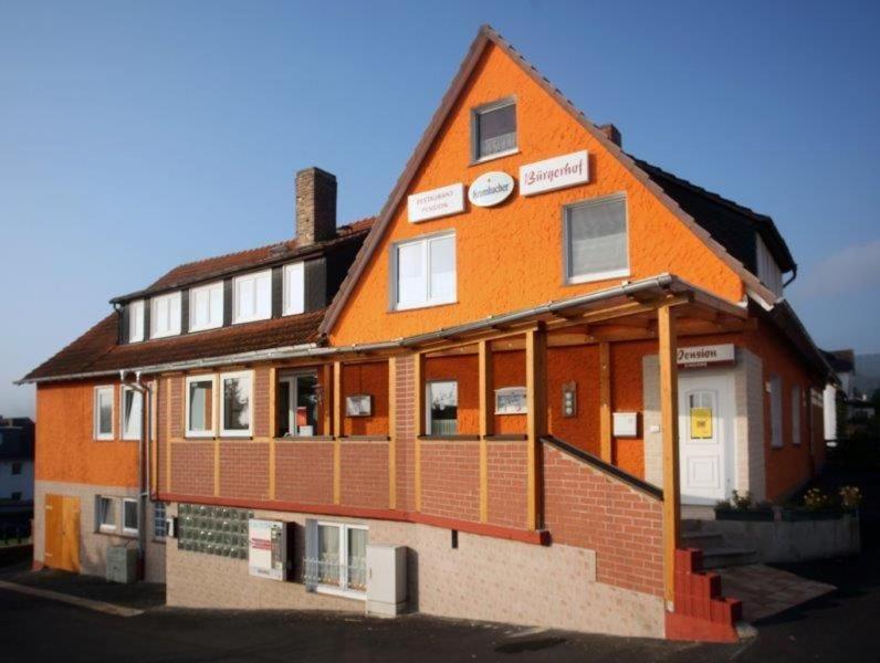 ein großes Gebäude mit einer orangefarbenen in der Unterkunft Restaurant-Pension Bürgerhof in Bad Zwesten