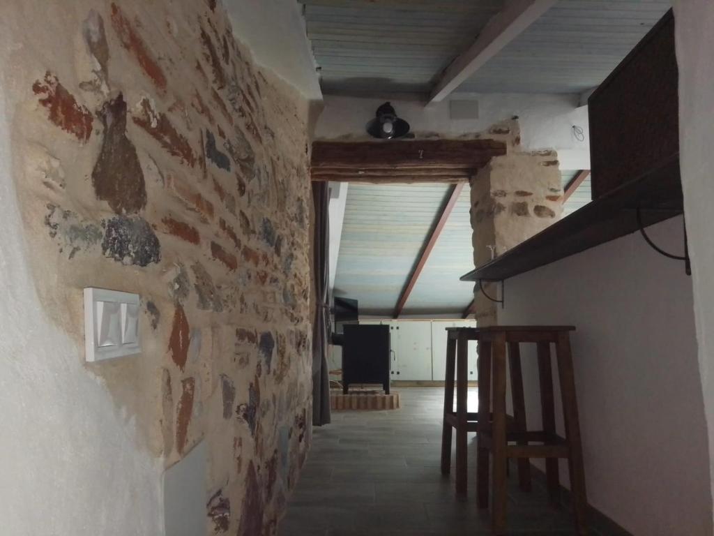 einen Flur mit einer Wand mit Gemälden darauf in der Unterkunft CASA CARMELA in Higuera de la Sierra
