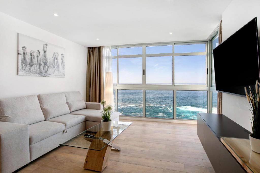 a living room with a couch and a large window at Luxury Loft El Roque 1 in Tacoronte