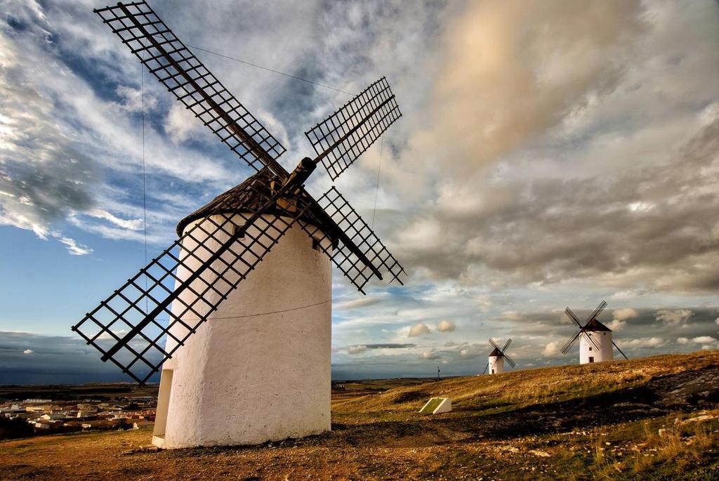 two windmills on a hill with a cloudy sky at Casa de la Mancha in Mota del Cuervo