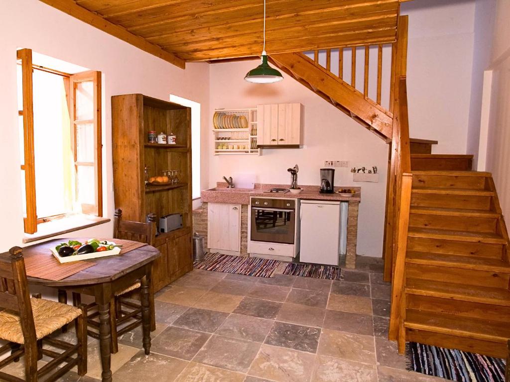 a kitchen with a table and a staircase in a house at Eveleos Country House in Tochni