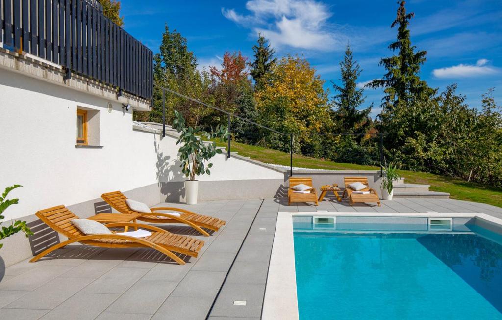 a swimming pool with lounge chairs next to a swimming pool at Holiday Home & Spa Kozji Vrh in Čabar