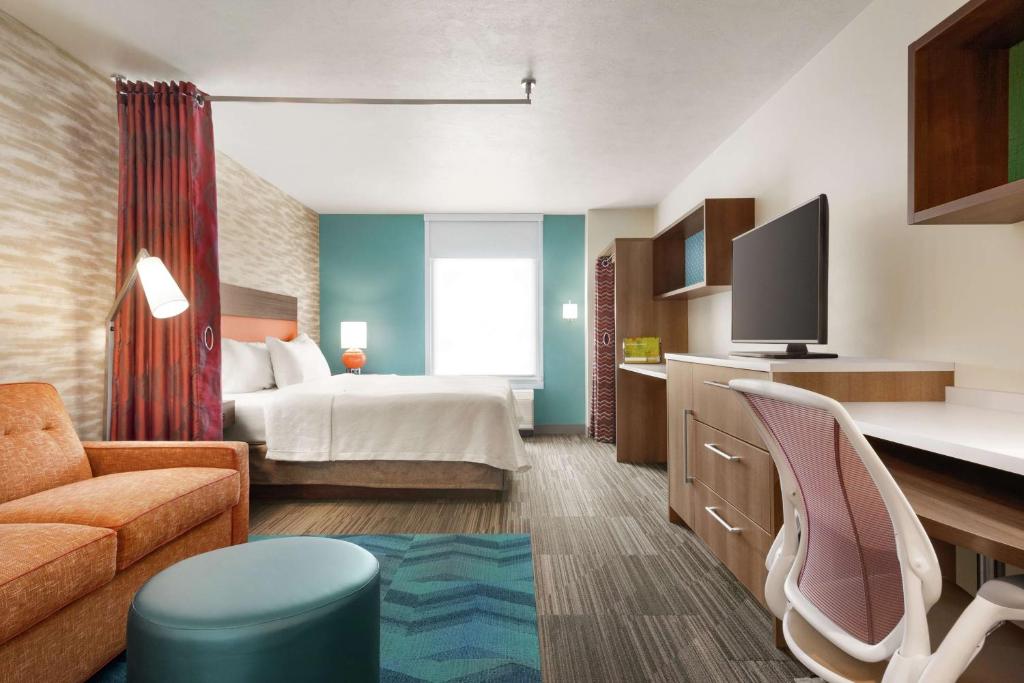 ノーマルにあるHome2 Suites By Hilton Bloomington Normalのベッドとソファ付きのホテルルーム