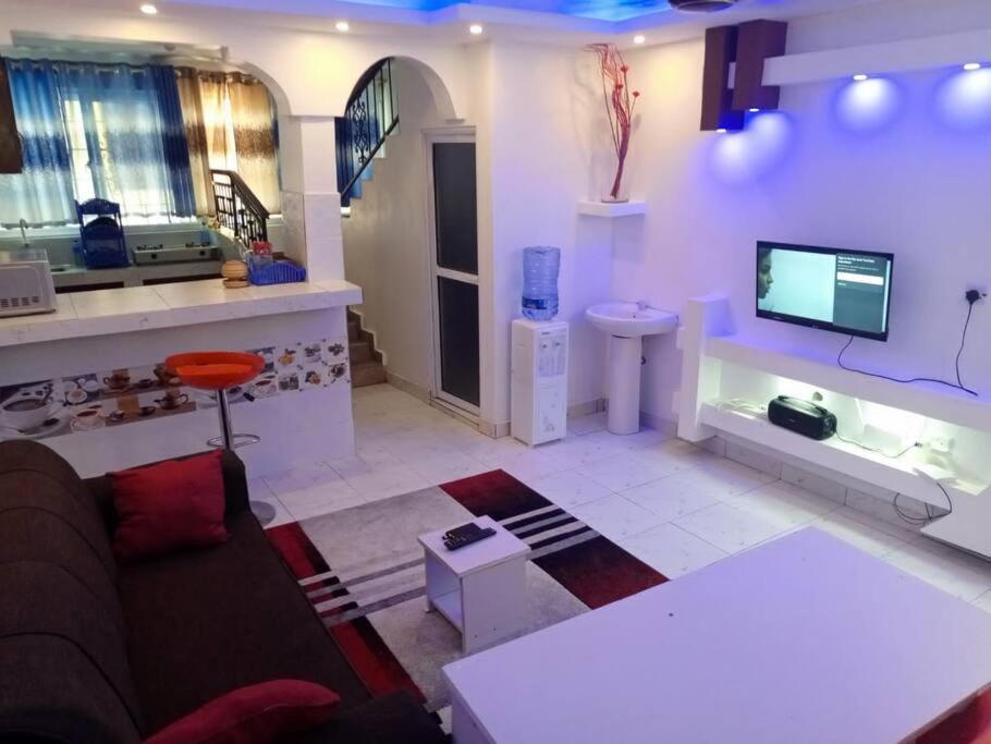 a living room with a couch and a tv at Storm Executive in Kilifi