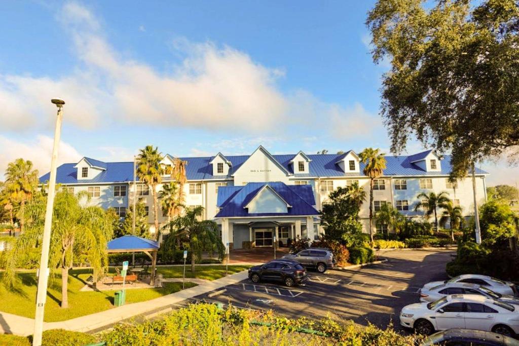 un grand bâtiment avec des voitures garées dans un parking dans l'établissement Seffner Inn and Suites, à Seffner