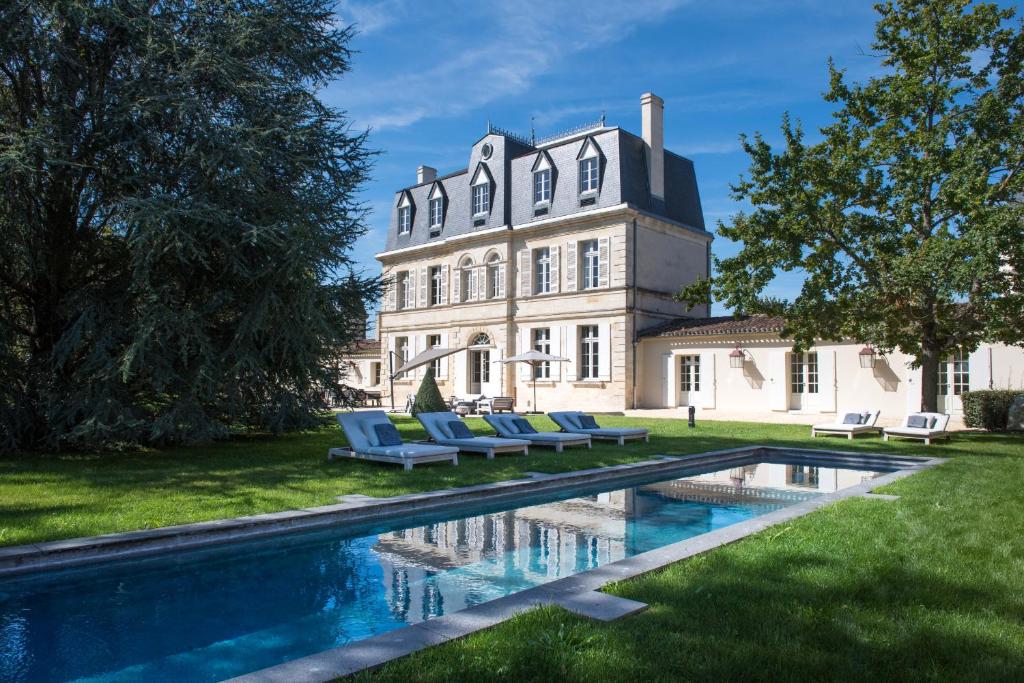 une maison avec une piscine en face de celle-ci dans l'établissement Live the castle life in Malescasse!, à Lamarque