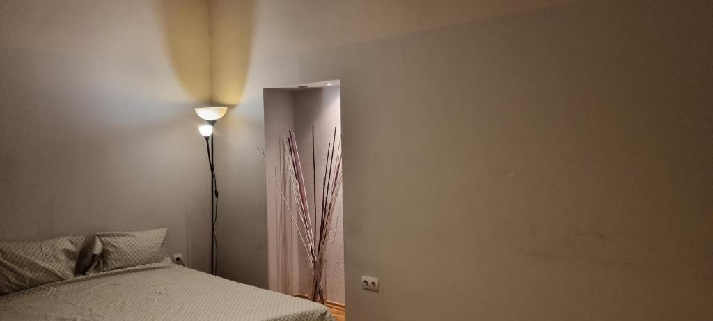 a bedroom with a bed next to a lamp at Bulb Apartment Budapest in Budapest