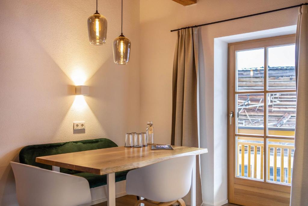 comedor con mesa, sillas y ventana en Mountain Residence Kasern Nr 3, en Predoi