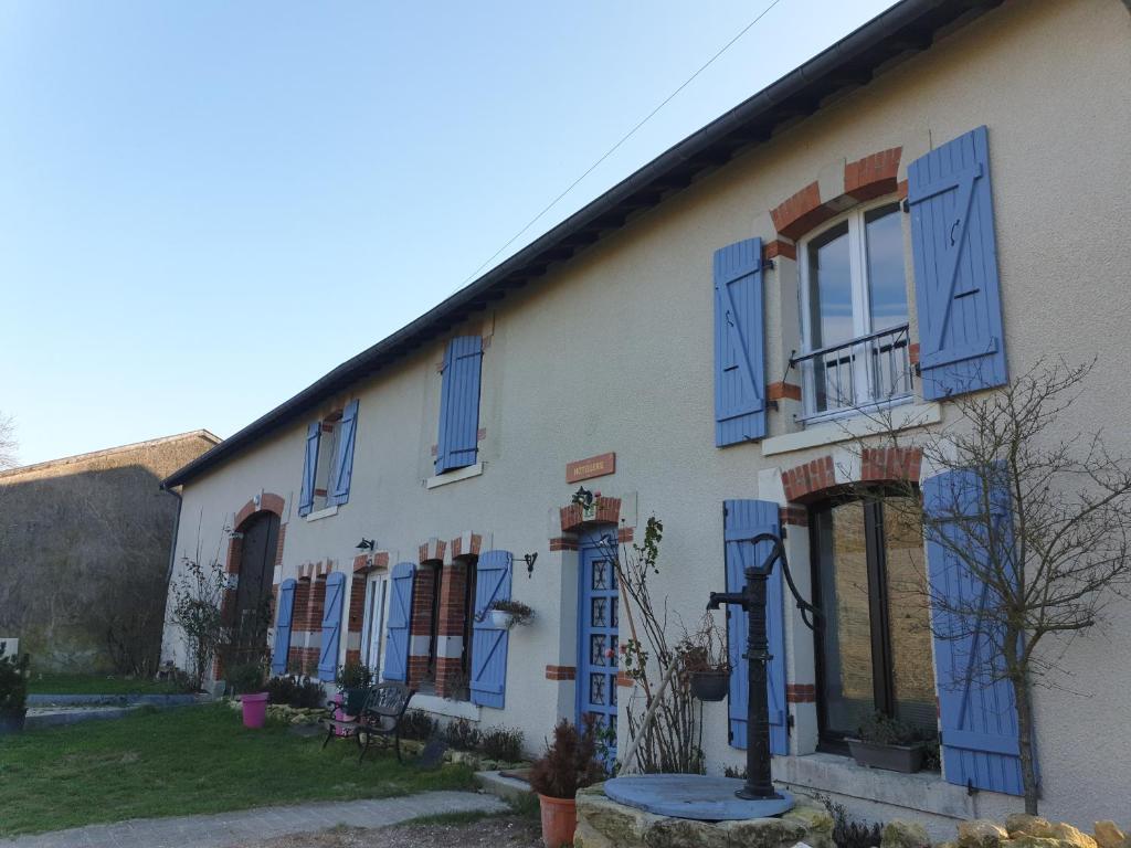 a white building with blue shutters on it at la longère chez marc et antoinette 