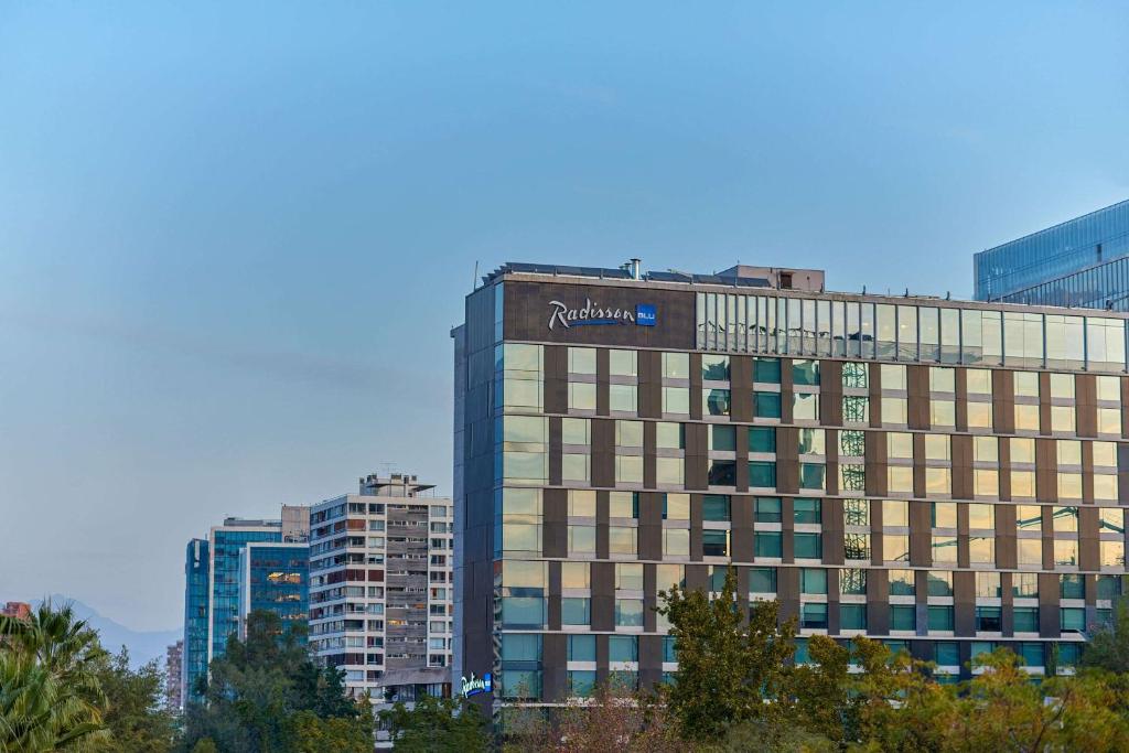 un edificio alto con un cartel en la parte superior en Radisson Blu Plaza El Bosque Santiago, en Santiago