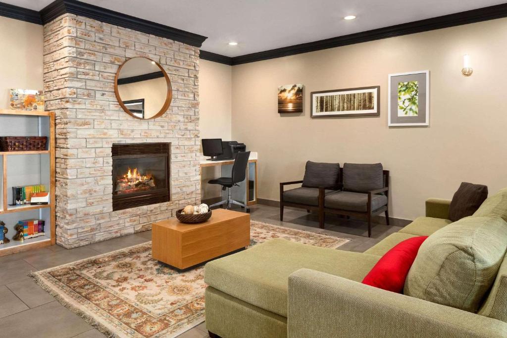 a living room with a couch and a fireplace at Country Inn & Suites by Radisson, Manteno, IL in Manteno