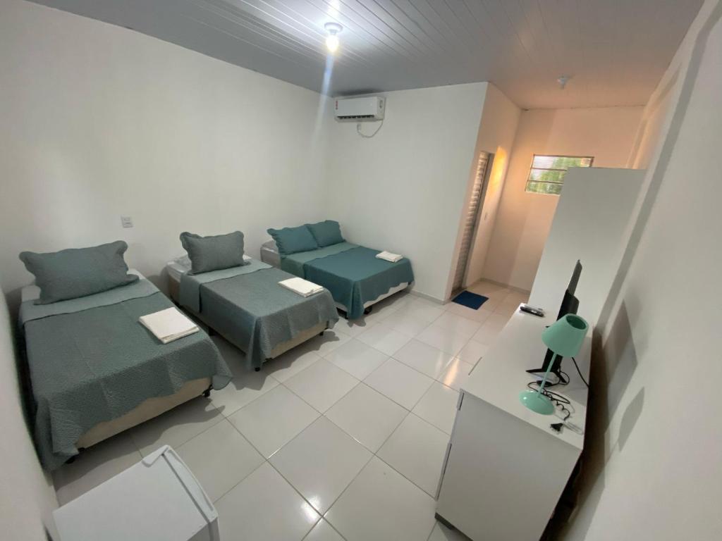 Sala de estar con 2 camas y mesa en Asas da Maré Pousada en Bragança