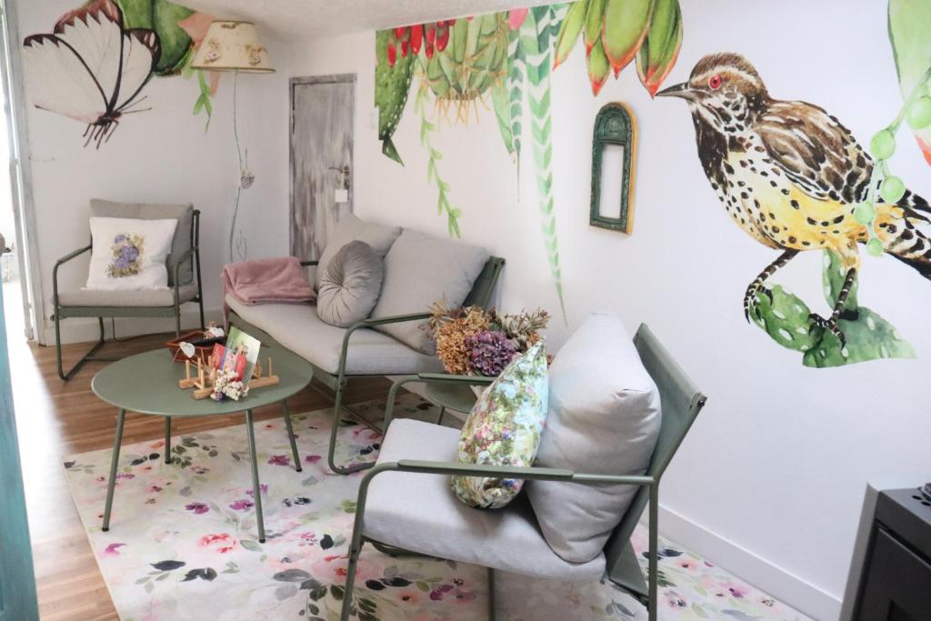 una sala de estar con un pájaro en la pared en Borboleta Guest House, en Figueira de Castelo Rodrigo