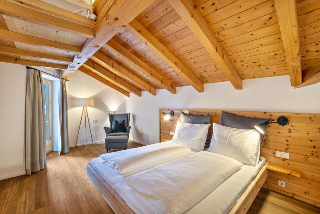 sypialnia z dużym łóżkiem w pokoju z drewnianym sufitem w obiekcie Mountain Residence Kasern Nr 4 w mieście Predoi