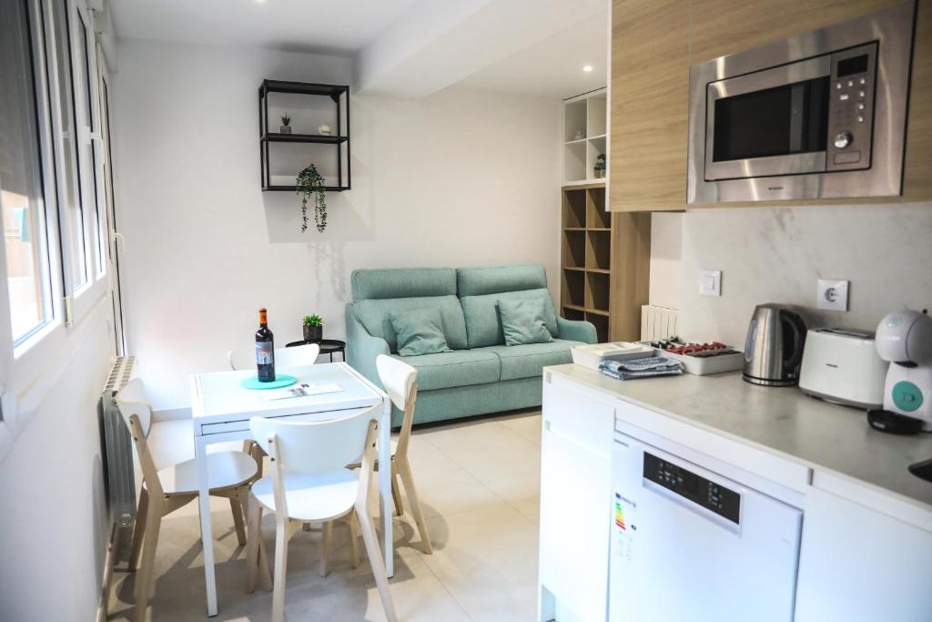 een keuken en een woonkamer met een tafel en een bank bij Apartamentos Sudestada in Logroño