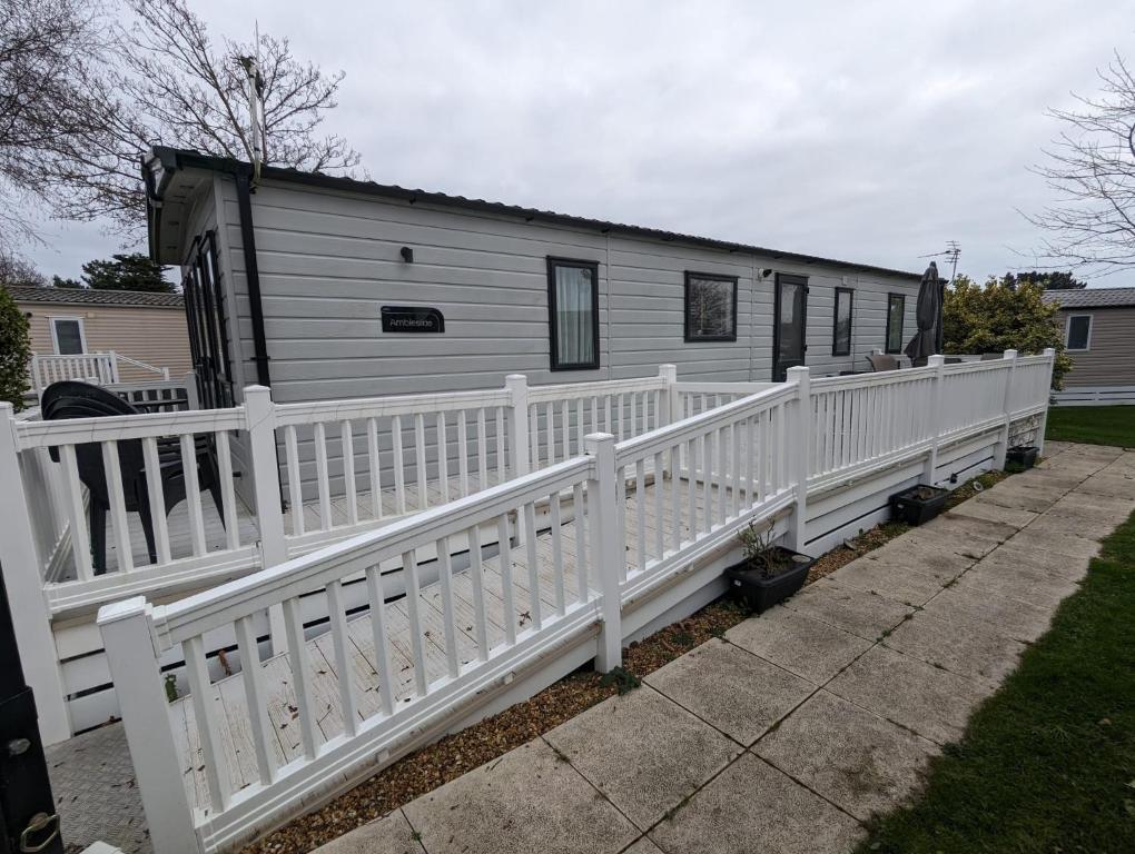 a white fence in front of a tiny house at Ambleside SHOREFIELD Holiday Park in Quiet cul de sac ENTERTAINMENT AND LEISURE PASSES INCLUDED in Milford on Sea