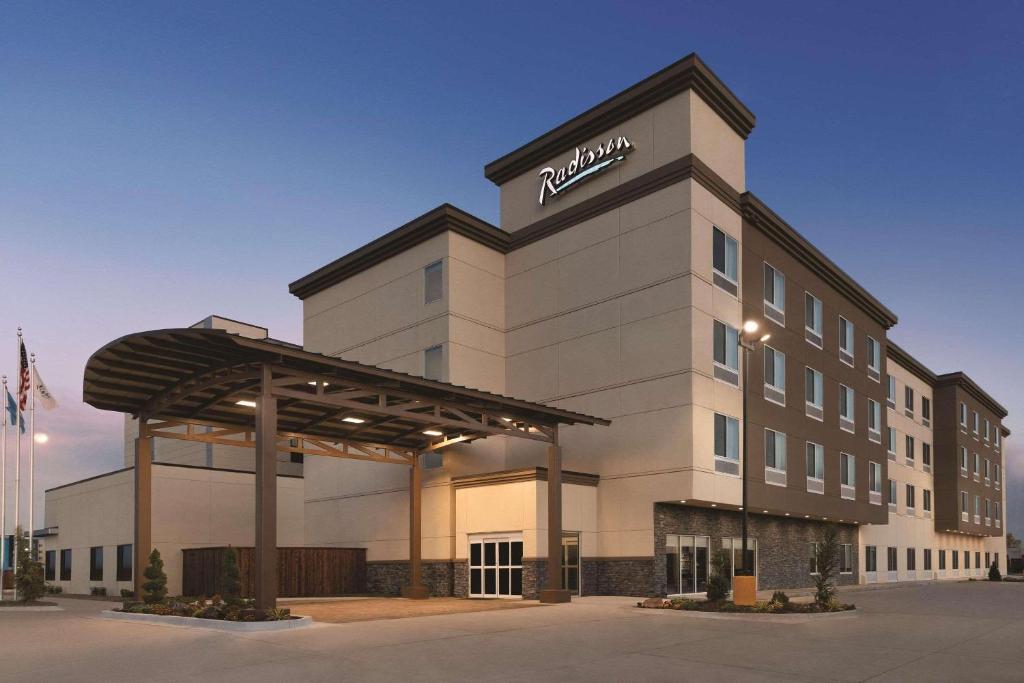 - un bâtiment d'hôtel avec un panneau nissan dans l'établissement Radisson Hotel Oklahoma City Airport, à Oklahoma City