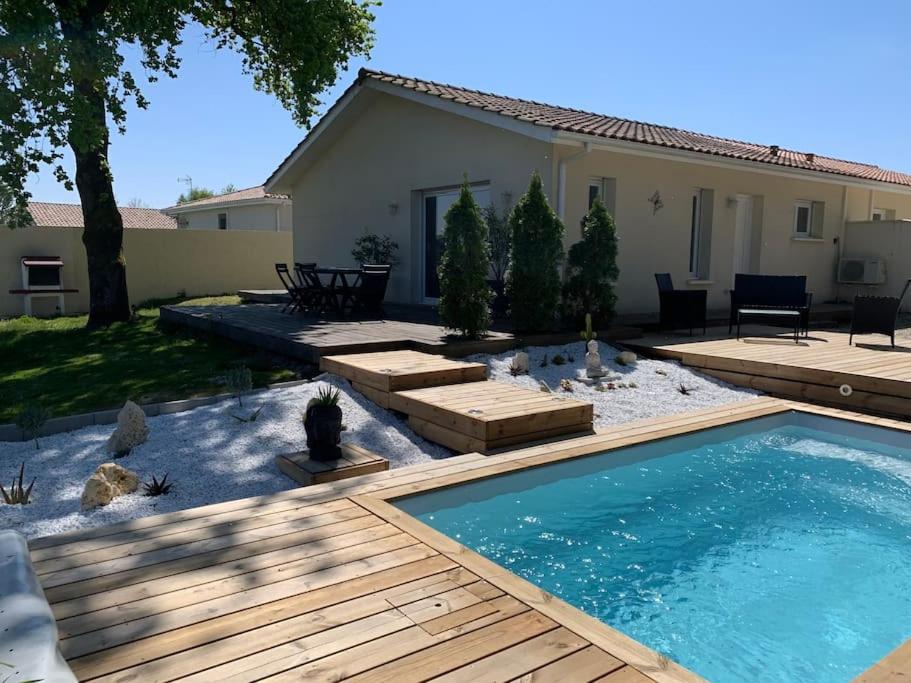um quintal com uma piscina e uma casa em Maison vue sur vignes Piscine chauffée Privée 6per BELLEVUE em Cussac-Fort-Medoc