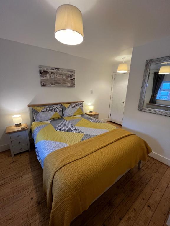 ein Schlafzimmer mit einem Bett mit einer gelben Decke in der Unterkunft Apartment 12, Sea Wharf in Westport