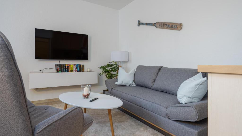 a living room with a couch and a tv at Gemütliches 2Zi App 4P 200m z Ostsee inkl Parkplatz in Kellenhusen