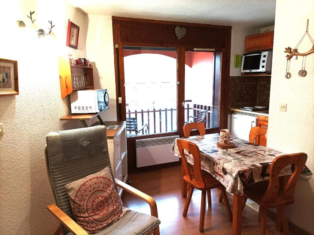 eine Küche und ein Esszimmer mit einem Tisch und Stühlen in der Unterkunft EDL11 - Studio 4 Pers centre des Carroz in Les Carroz d'Araches