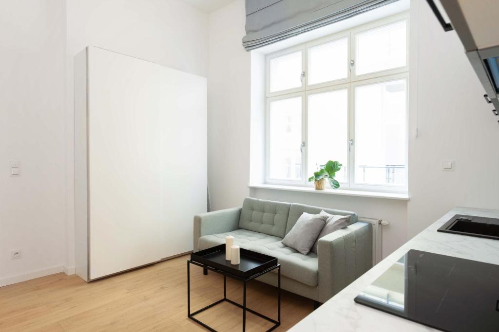 uma sala de estar com um sofá e uma mesa em The Bank Poznan Apartments em Poznań