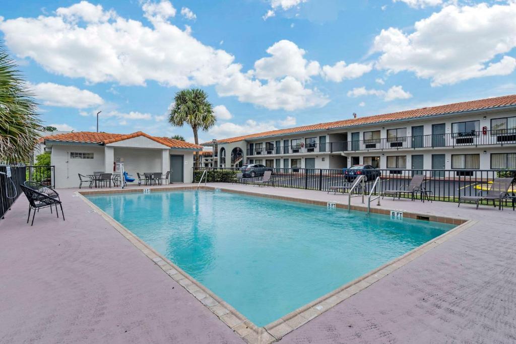 a large swimming pool in front of a building at Quality Inn & Suites Orlando East - UCF Area in Orlando