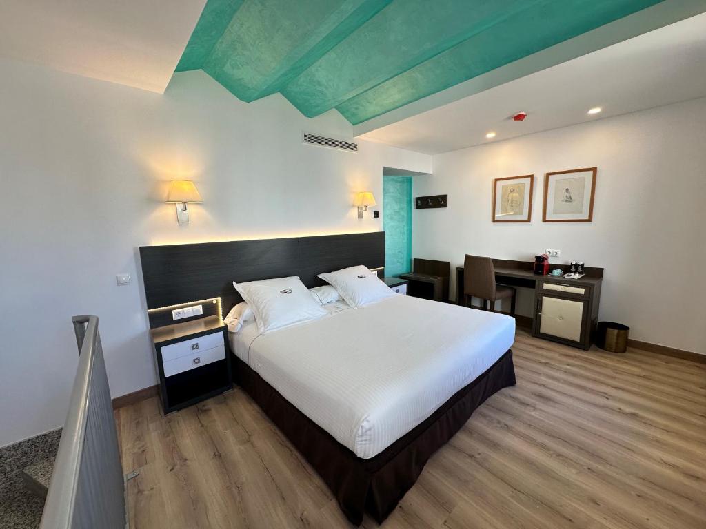 a bedroom with a large bed with a desk and a desk at Antídoto Rooms Zocodover in Toledo