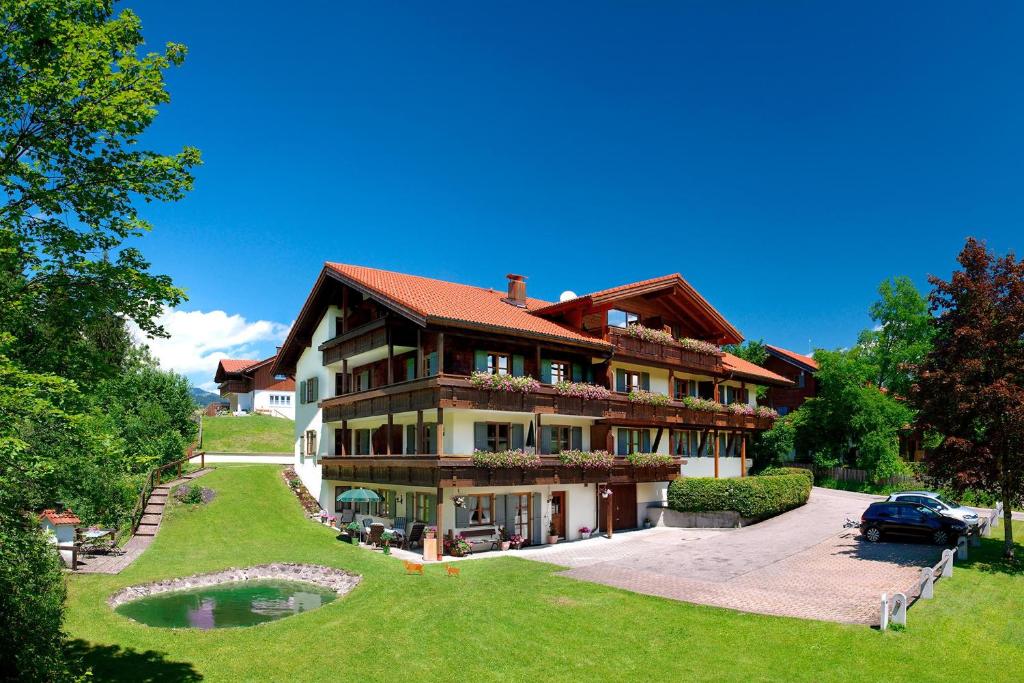 una casa grande con un coche aparcado delante de ella en Landhaus Bachtelmühle, en Bolsterlang