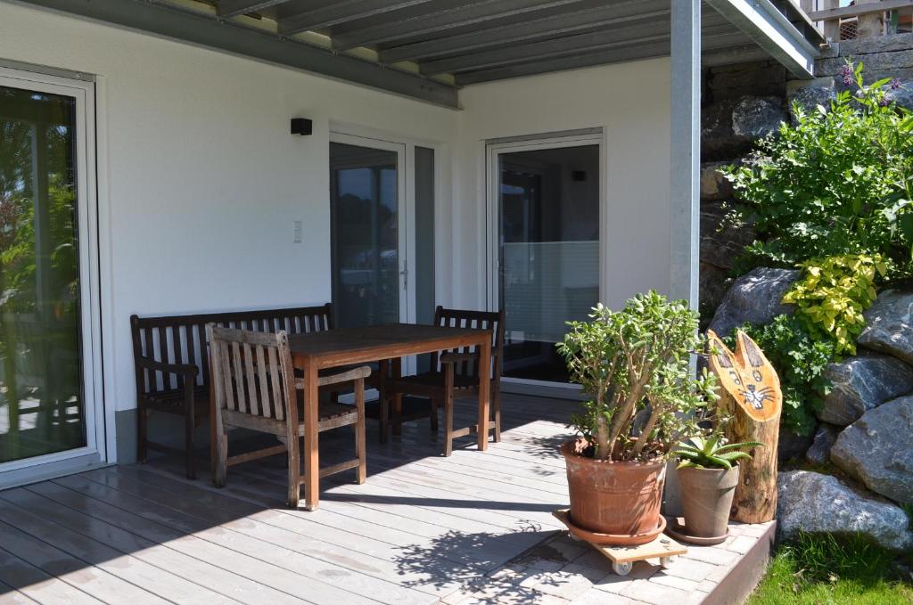 einen Holztisch und zwei Bänke auf einer Terrasse in der Unterkunft Ferienwohnung Geng in Überlingen