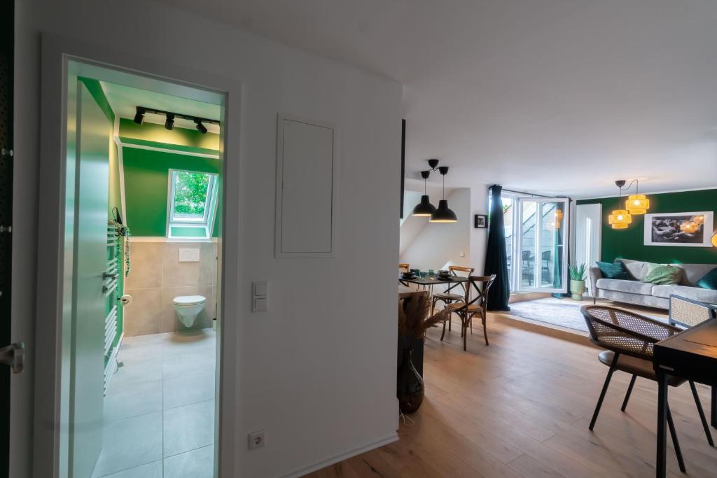 a living room and dining room with green walls at Rooftop Suite Essen Central-Fair-HBF-Uniklinik-Balcony-Walk-In Shower-Coffee station-WiFi-Workspace in Essen