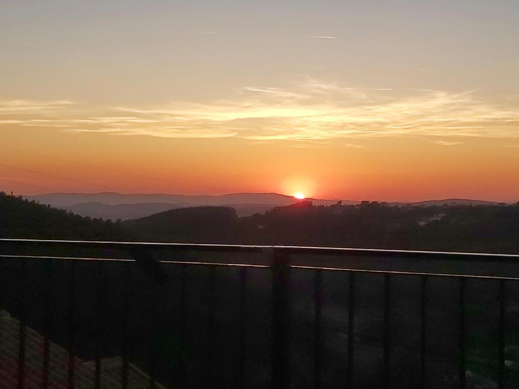 a sunset with the sun setting in the mountains at Casa de Xisto in Arganil