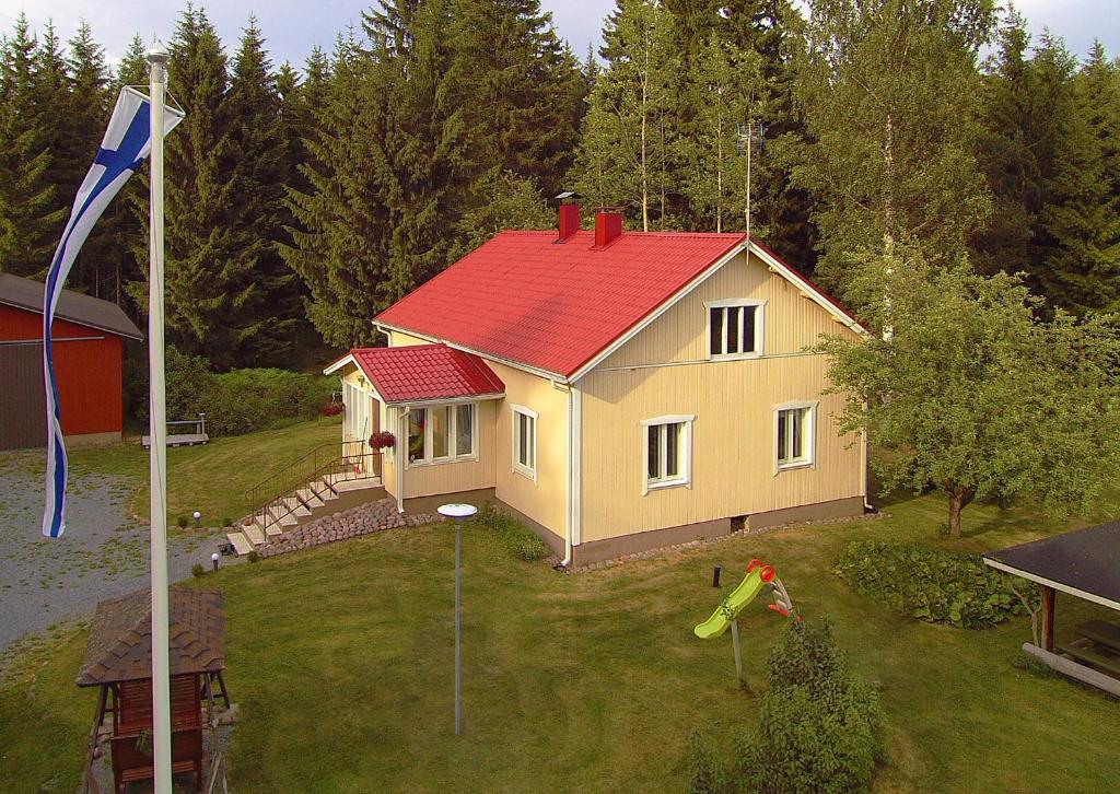 a small house with a red roof and a flag at B&B Kommee Kurki in Sastamala