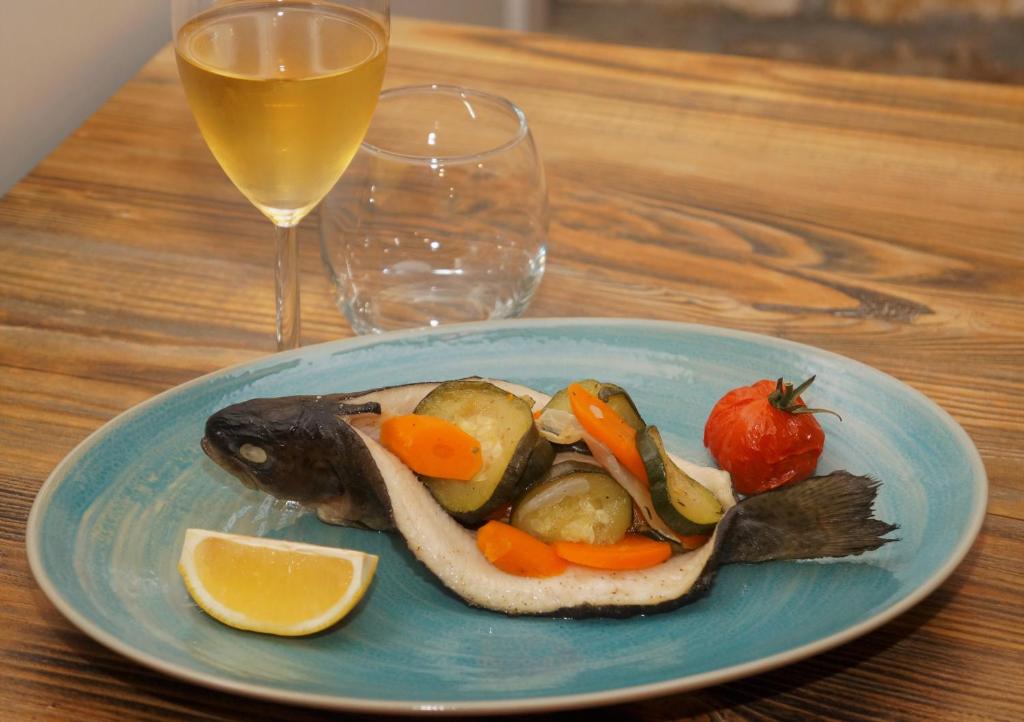 un piatto di cibo con un pesce e verdure su un tavolo di hotel de l'ain a Pont-de-Poitte