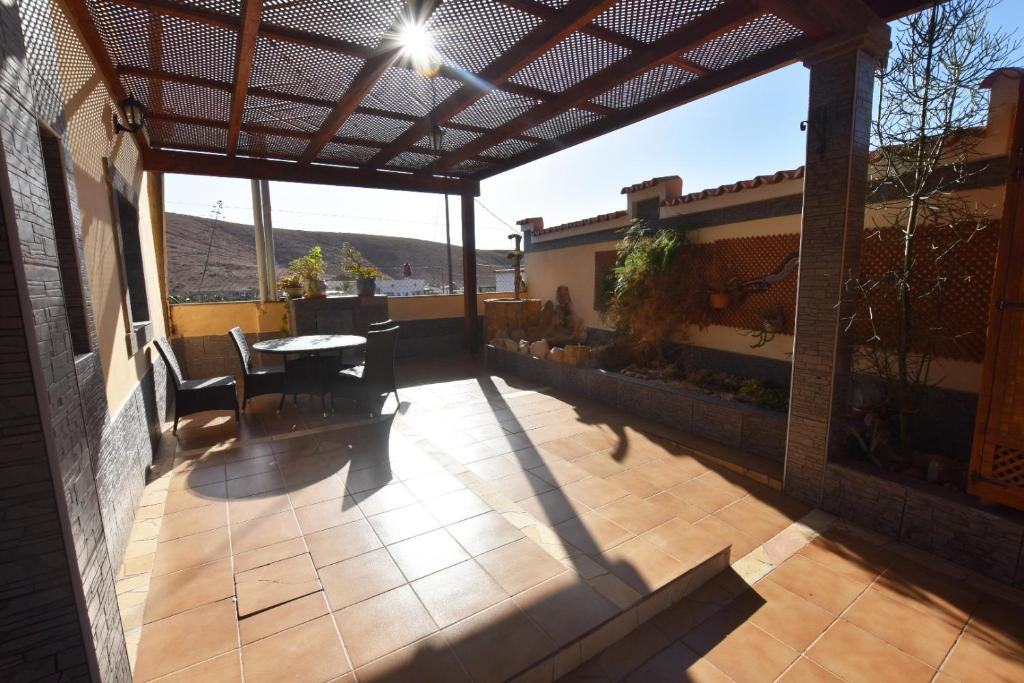 a patio with a table and chairs on a house at Book Jet - Villa Vacacional libertad Pajara 