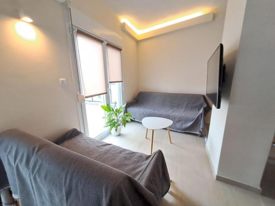 Sala de estar con 2 camas y mesa en Parkview Central Apartment - Xanthi, en Xanthi