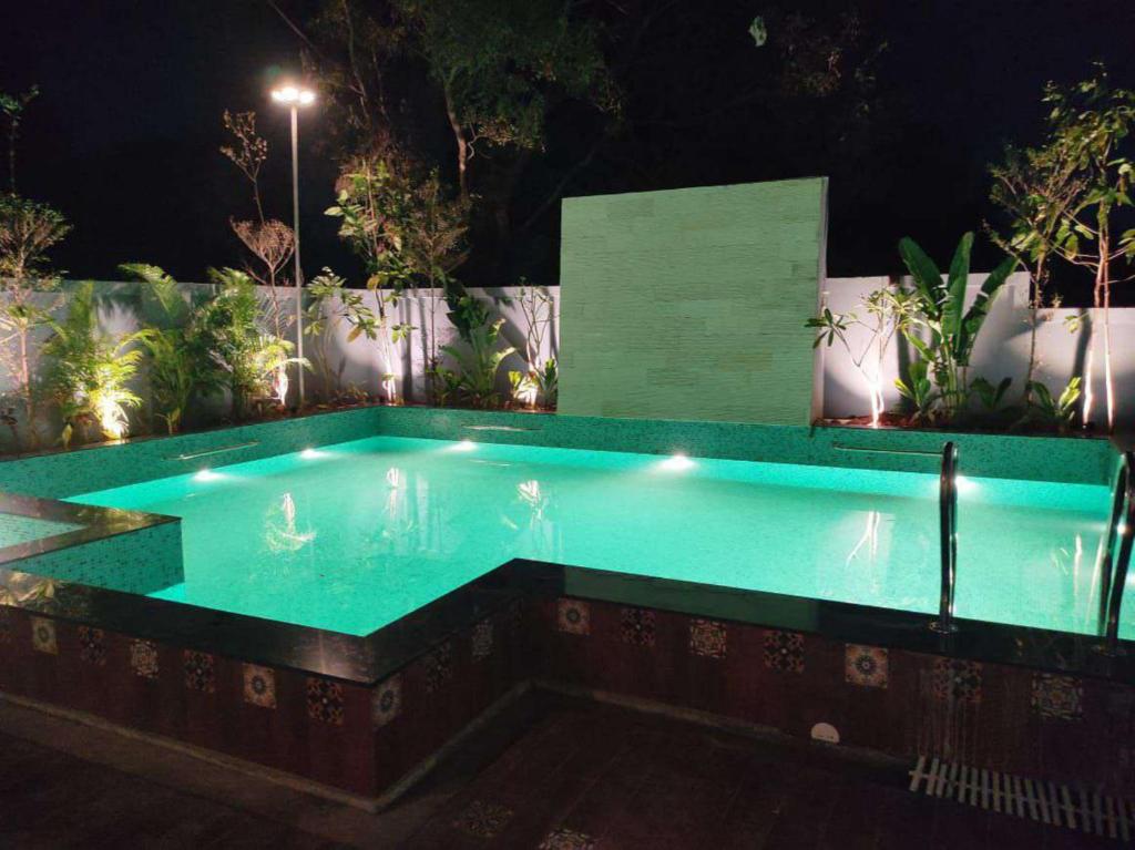 a swimming pool at night with lights in it at Curtis House in Hyderabad