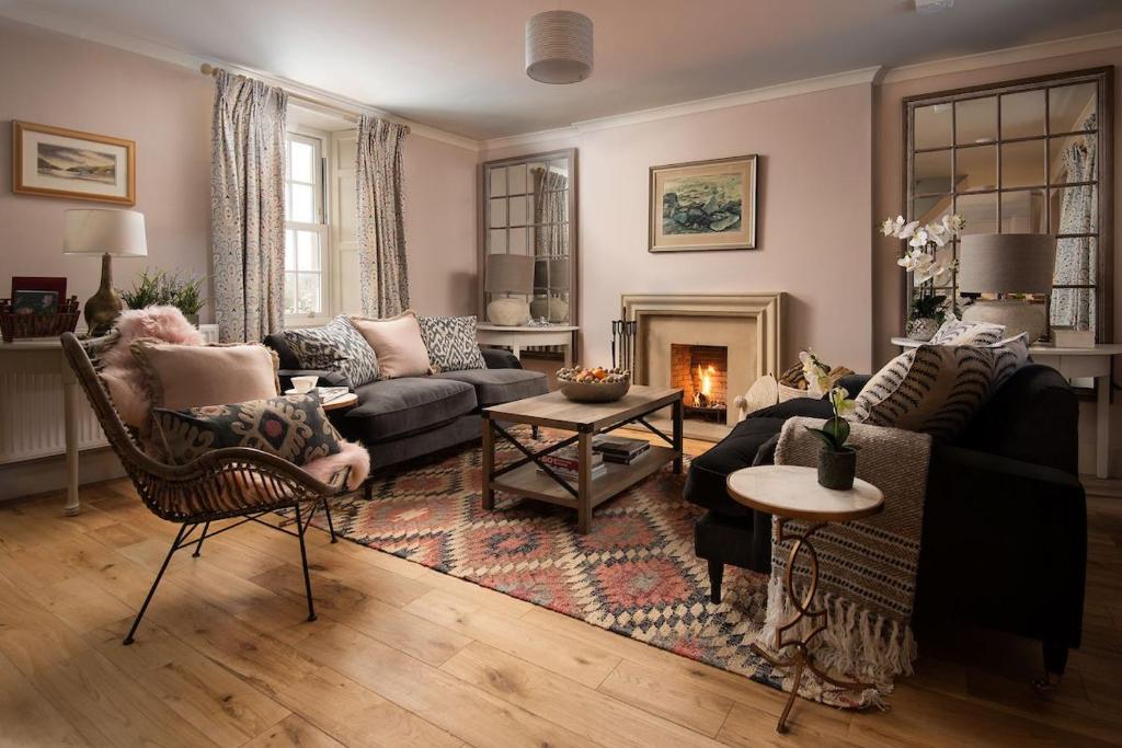 a living room with a couch and a fireplace at Bughtrig Cottage in Coldstream