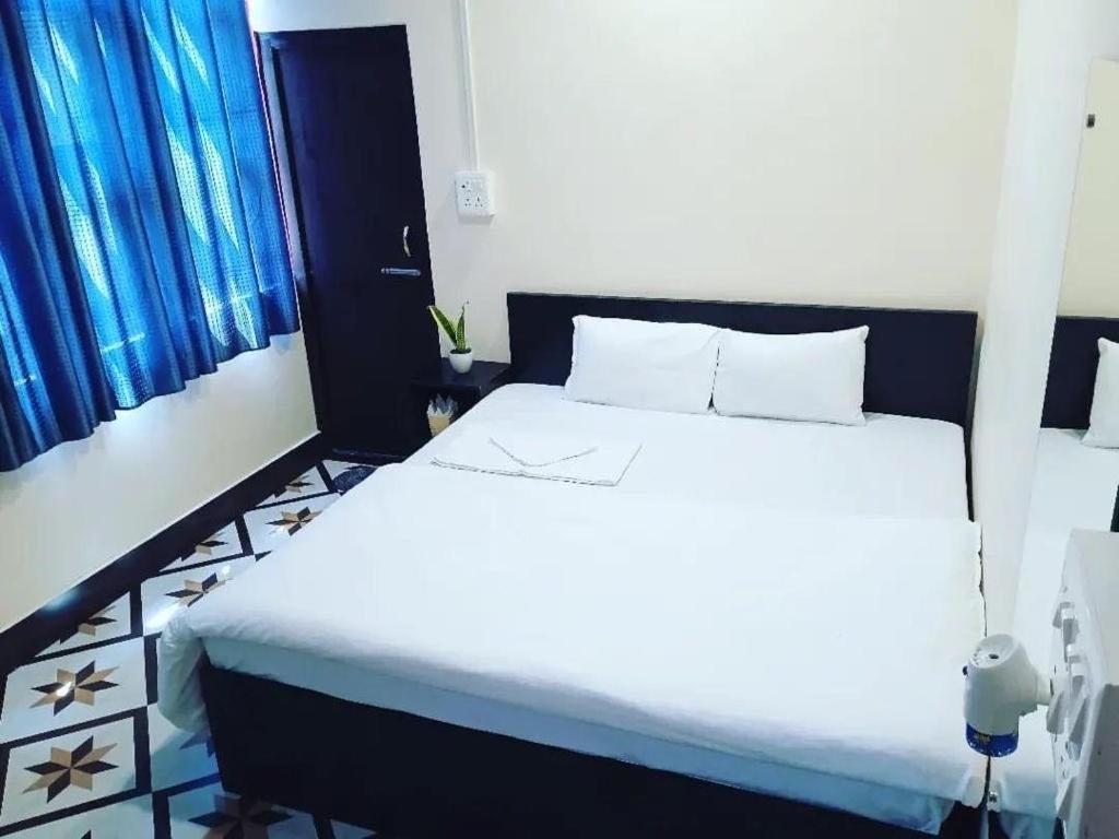 ein Schlafzimmer mit einem großen weißen Bett in einem Zimmer in der Unterkunft OYO Flagship The Thangal Hotel in Imphal