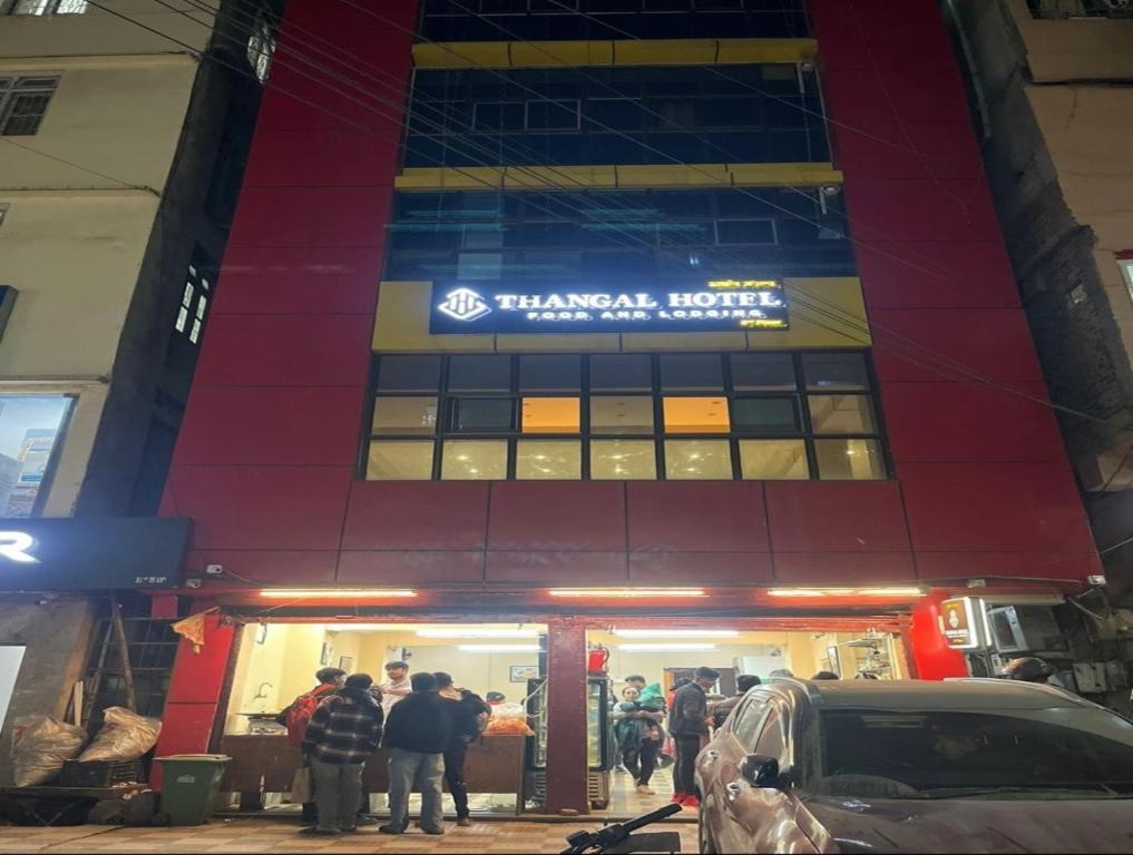 a group of people standing outside of a building at OYO Flagship The Thangal Hotel in Imphal