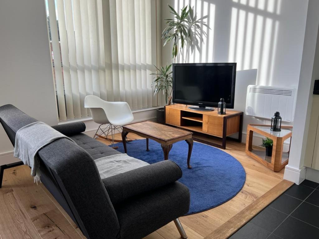a living room with a couch and a tv at Delightful & Spacious Flat in London - Peckham in London