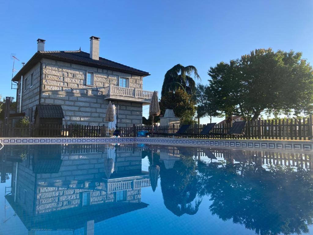een huis wordt weerspiegeld in een zwembad van water bij CASA LUMERMA in Taboadela