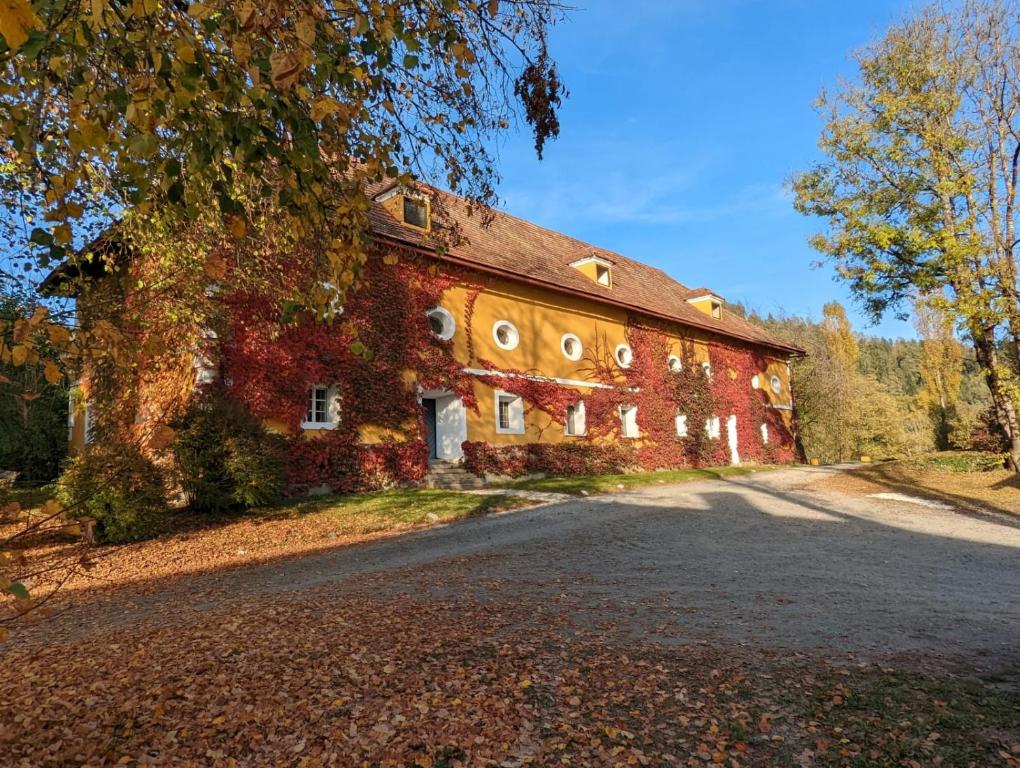 eine alte rote Backsteinscheune mit einer Straße davor in der Unterkunft Ferienwohnung Ottmanach Schlosshof in Pischeldorf