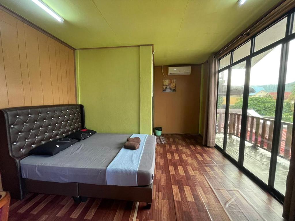 ein Schlafzimmer mit einem Bett in einem Zimmer mit Fenstern in der Unterkunft Perhentian Hazipah in Perhentian Island